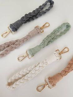 four different colored rope leashs with gold hooks on each side and one is white, beige