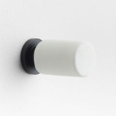 a black and white knob on a white wall