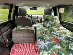 the interior of a vehicle with a bed and wicker basket in the passenger seat