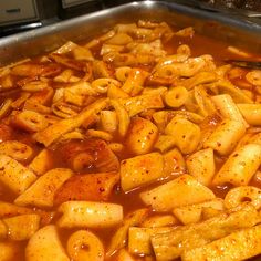 a pan filled with pasta and sauce on top of a stove