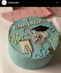 a blue cake decorated with an image of a skeleton holding a book and graduation cap