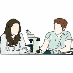 two people sitting at a table with microscopes