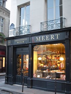 a store front with many items on display in it's windows and the sidewalk below