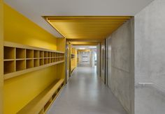 the hallway is lined with yellow shelves and shelving units on either side of the wall