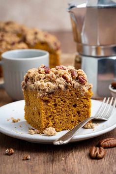 a piece of pumpkin coffee cake on a plate with a fork and cup in the background