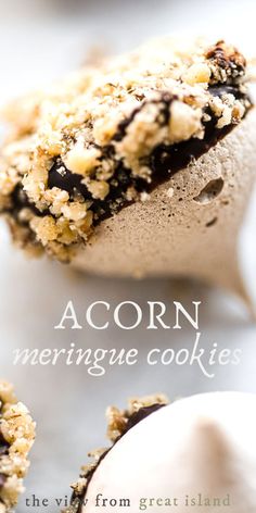 a close up of an ice cream sandwich with crumbs on it and the words acorn meringue cookies