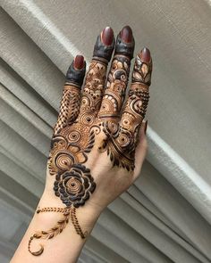 a woman's hand with henna tattoos on it