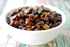 a white bowl filled with raisins sitting on top of a colorful table cloth