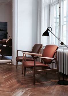 a living room filled with furniture next to a window and a painting on the wall