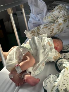 a baby laying on top of a hospital bed