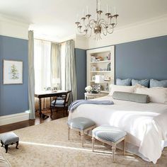 an image of a bedroom with blue walls and white furniture in the room, including a bed