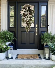 the front door is decorated with plants and wreaths