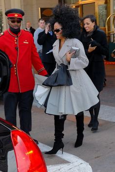 a woman in a dress is walking next to a man in a red coat and hat