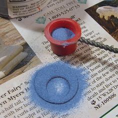 a blue substance is being used to create an image on paper with scissors and glue