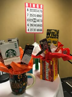 a table with a coffee cup and candy bar wrapped in orange ribbon, next to a sign that says bingo