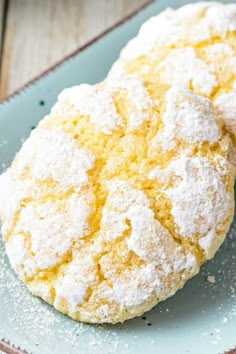 two powdered sugar cookies on a plate