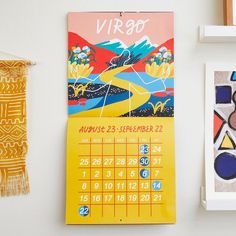 a calendar hangs on the wall next to other art