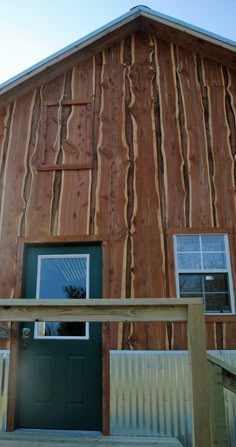 a wooden building with a green door and window