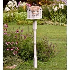 a bird house on a post in the garden