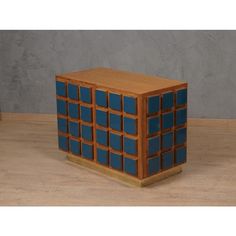 a wooden block with blue squares on it in front of a gray wall and wood floor