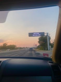 the view from inside a car looking at a street sign