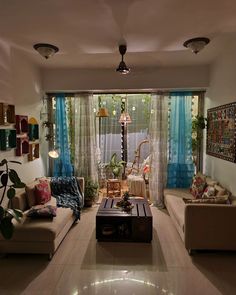 a living room filled with lots of furniture next to a window covered in blue curtains