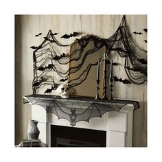 a mantel topped with a mantle covered in black spider webs and a mirror