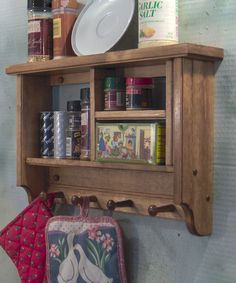 an old wooden shelf with spices and other items on it's sides, hanging from the wall