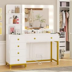 a white vanity with gold handles and drawers in a room next to a wall mounted mirror