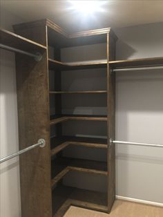 an empty walk - in closet with shelves and bars on the bottom level, is shown