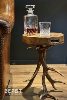 a wooden table with two glasses on it next to a brown leather chair and couch