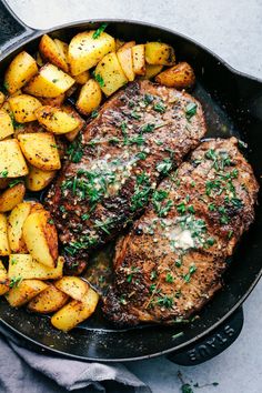 steak and potatoes in a cast iron skillet on a table with a gray napkin