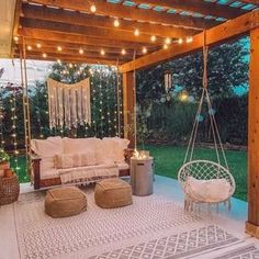 an outdoor living area with lights strung up on the ceiling and hanging from the roof