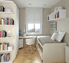 a bedroom with a bed, desk and bookshelf in the middle of it