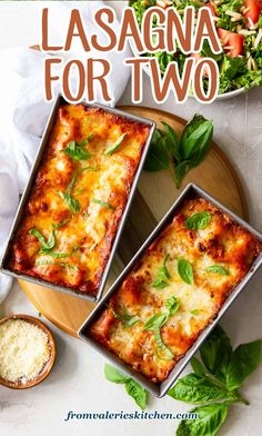 two pans filled with lasagna sitting on top of a wooden cutting board