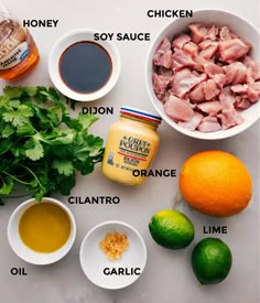 ingredients to make mexican chicken salad laid out on a white counter top with limes, cilantro, mayonnaise, and seasoning