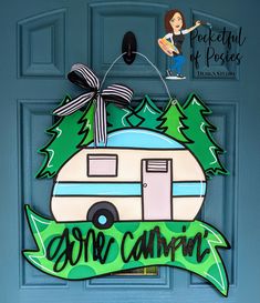 a door hanger with a camper and trees on it that says, one camping