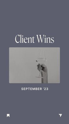 a hand holding a wine glass with the words client wins written on it in white