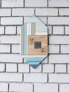 a white brick wall with a blue and brown wooden plaque on it's side