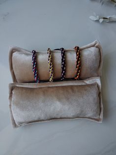 three bracelets sitting on top of a pillow