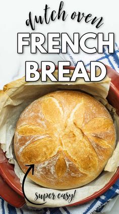 a loaf of bread sitting in a red bowl on top of a blue and white towel