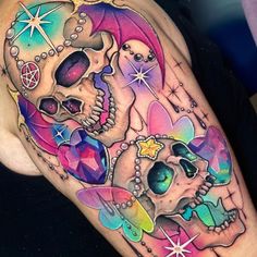 a colorful tattoo with skulls and stars on it