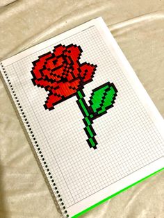 a cross stitch rose on a sheet of paper