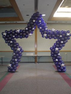 an arch made out of balloons in the shape of a star with stars on it