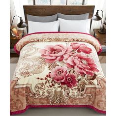 the comforter is made up with pink flowers on it