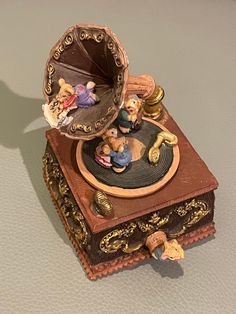 an antique trinket with figurines in it sitting on top of a table