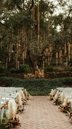 an outdoor ceremony setup with white chairs and flowers