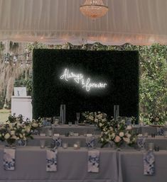 an image of a wedding reception setup with lights and flowers on the head table at this outdoor venue