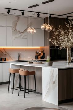 a kitchen with marble counter tops and stools next to an island in the middle