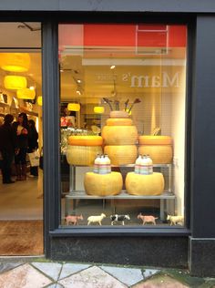 a store front with many cheeses in the window